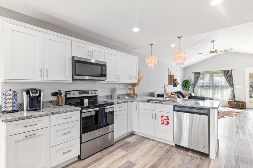 a kitchen with white cabinets and black appliances at Safar by the Sea in Davis Shores in Saint Augustine