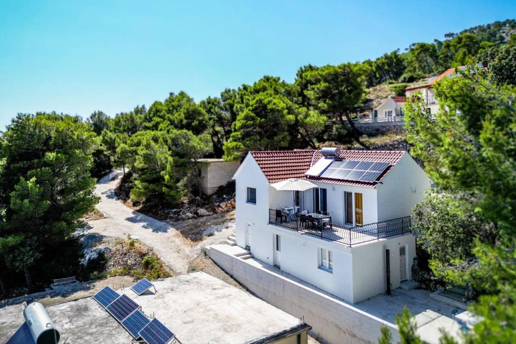 an aerial view of a white house with solar panels at Kuća za odmor Farska in Nerežišće