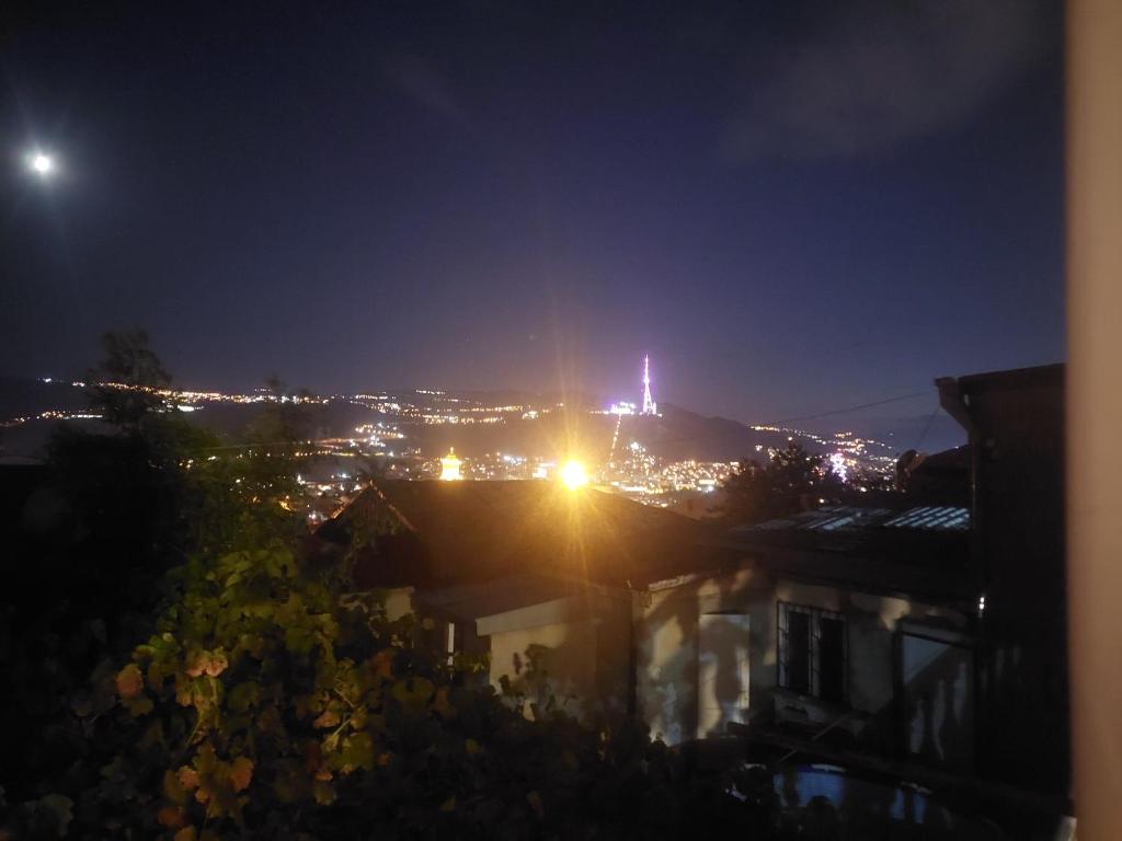 - une vue sur une ville éclairée la nuit dans l'établissement RADENO HOUSE, à Tbilissi