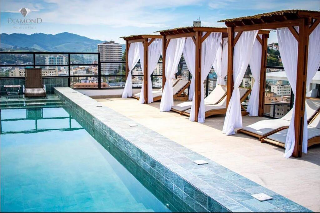 a hotel swimming pool with a view of the city at Flat lindo com piscina e linda vista da cidade in São Lourenço