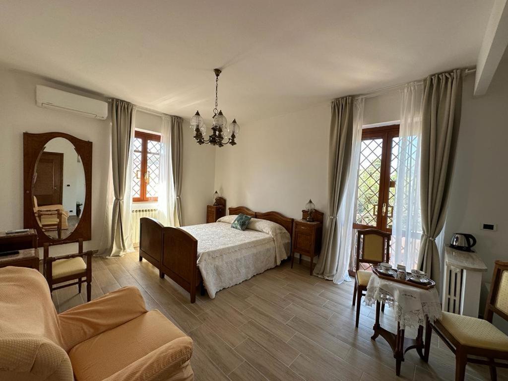 een slaapkamer met een bed en een woonkamer bij Il Sogno delle Rondini in Palidoro