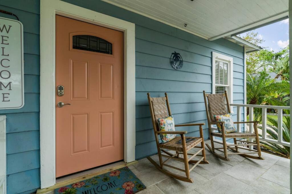 a front door of a blue house with two rocking chairs at Blue Haven Beach Hot Tub History in St. Augustine