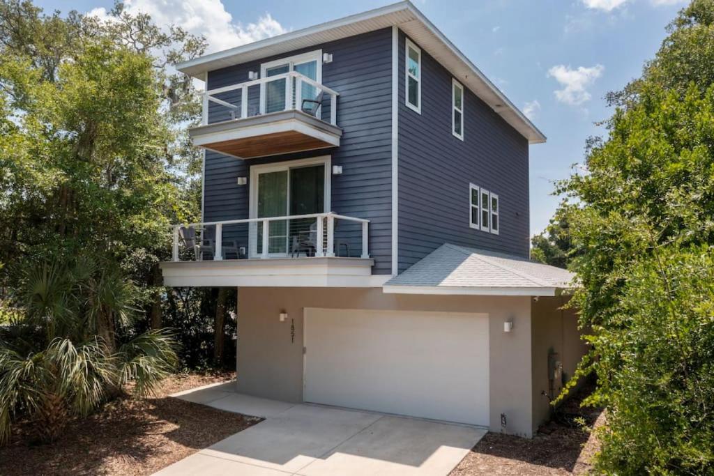 a blue house with a balcony and a garage at Treehouse By the Sea in St. Augustine