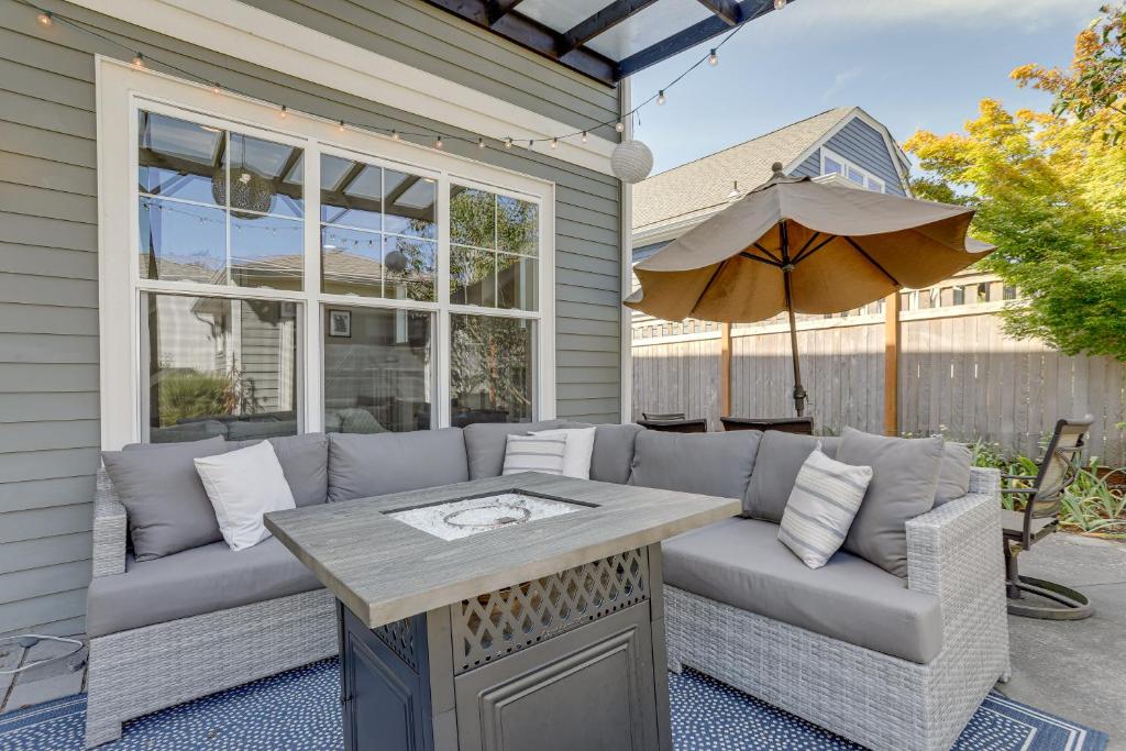 eine Terrasse mit einem Sofa und einem Sonnenschirm in der Unterkunft Washington Retreat with Balcony, Patio and Fire Pit! in Seattle