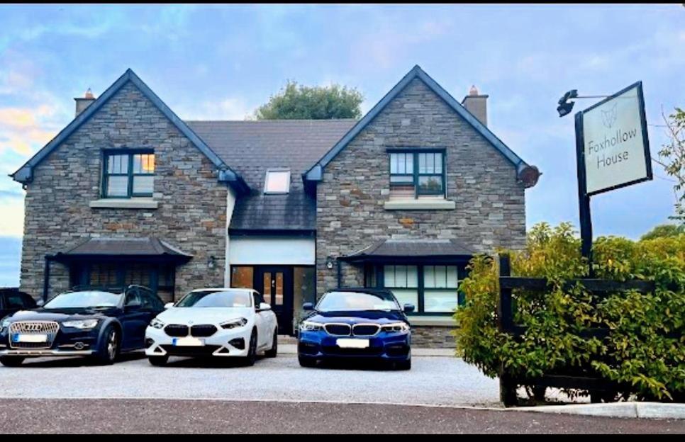 dos autos estacionados frente a una casa en Foxhollow House Suite en Blarney