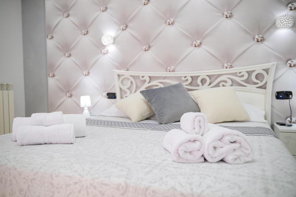 una camera da letto bianca con due asciugamani su un letto di Venere apartement house a Montalto Uffugo