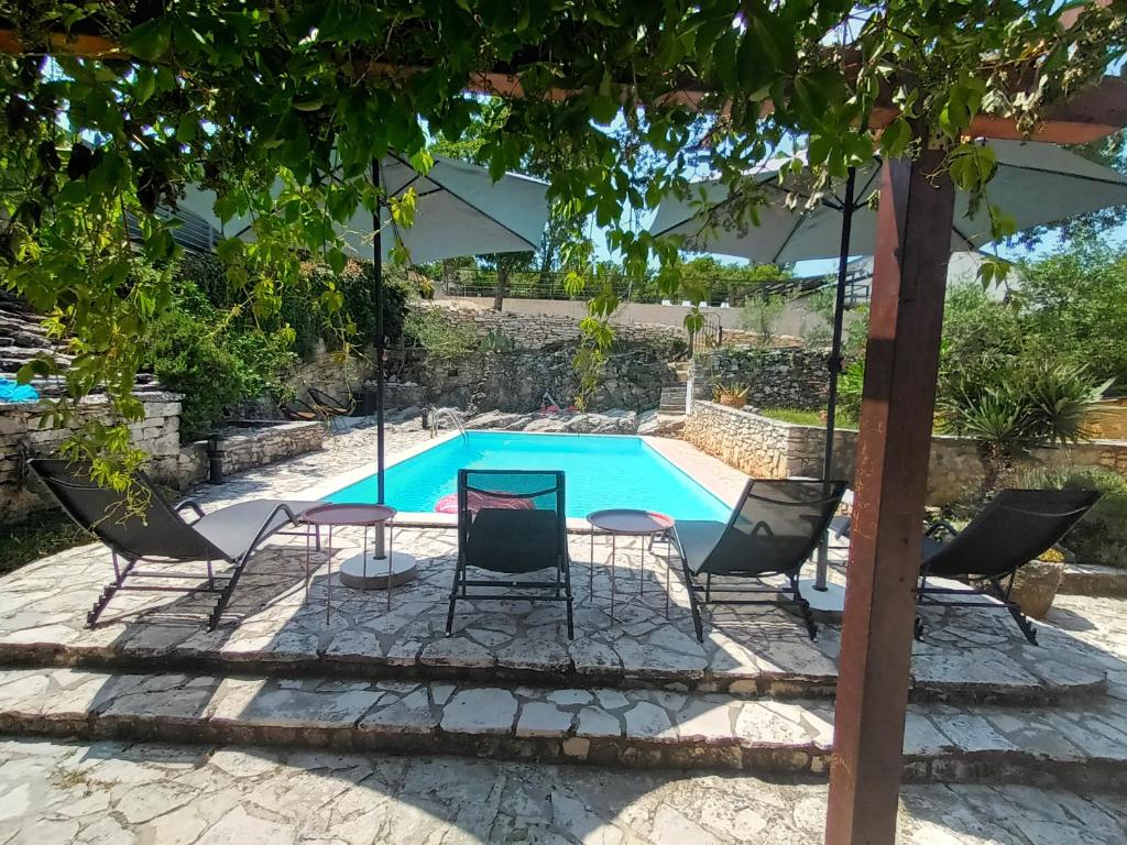 a group of chairs and a table by a swimming pool at Villa Giovanna in Rakalj