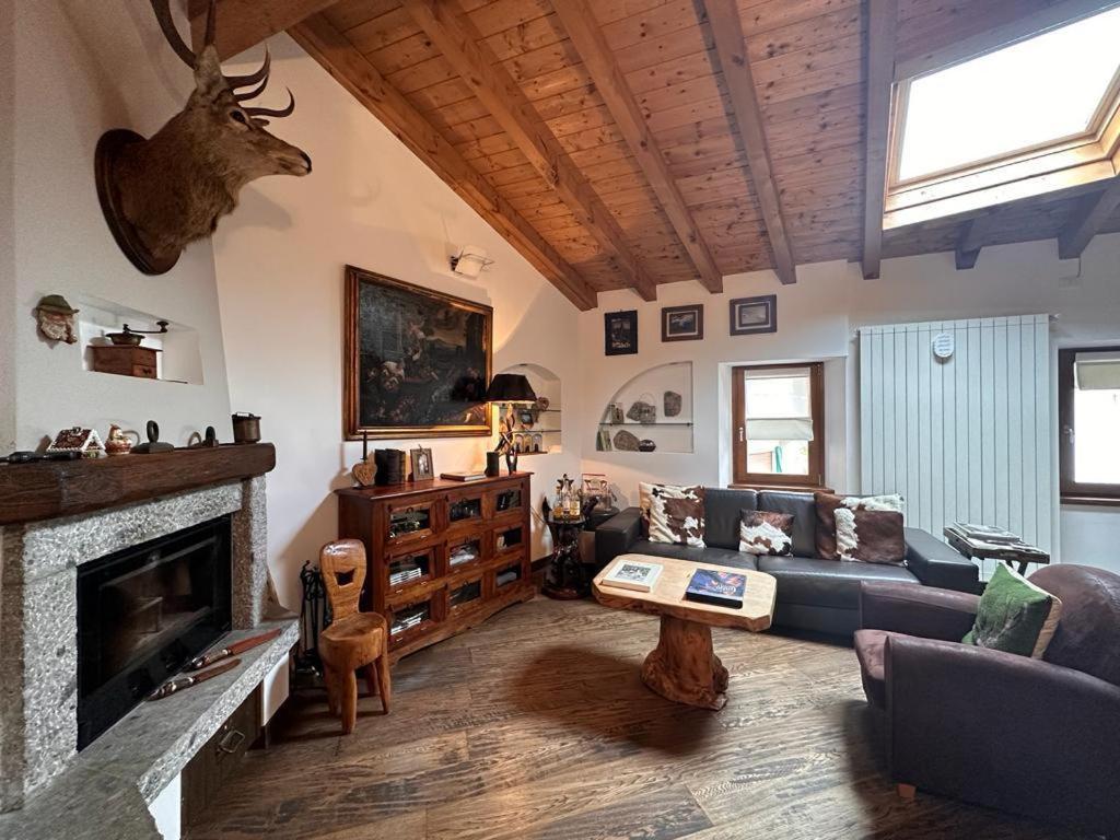 ein Wohnzimmer mit einem Sofa und einem Kamin in der Unterkunft Nido Mountain Apartment in Castione della Presolana