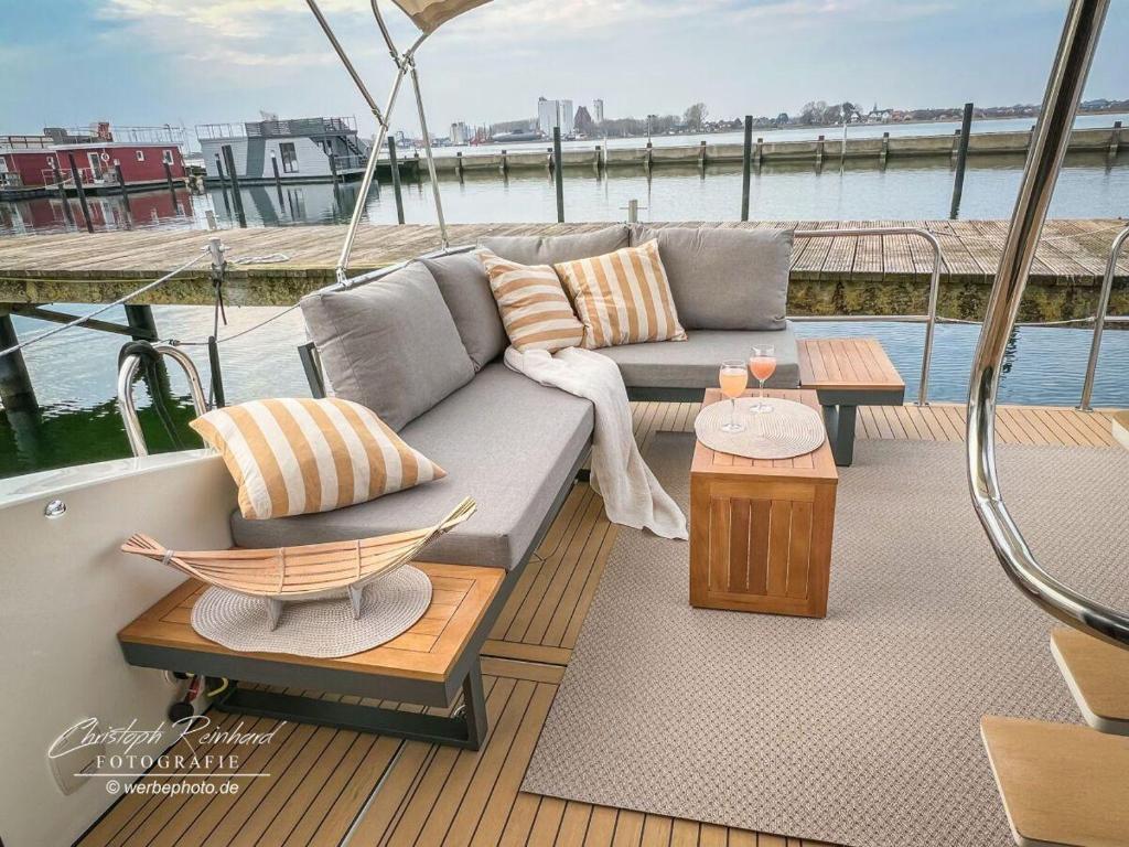 a couch and tables on a deck of a boat at Motoryacht-Futura-Urlaub-im-Yachthafen in Burgtiefe auf Fehmarn 