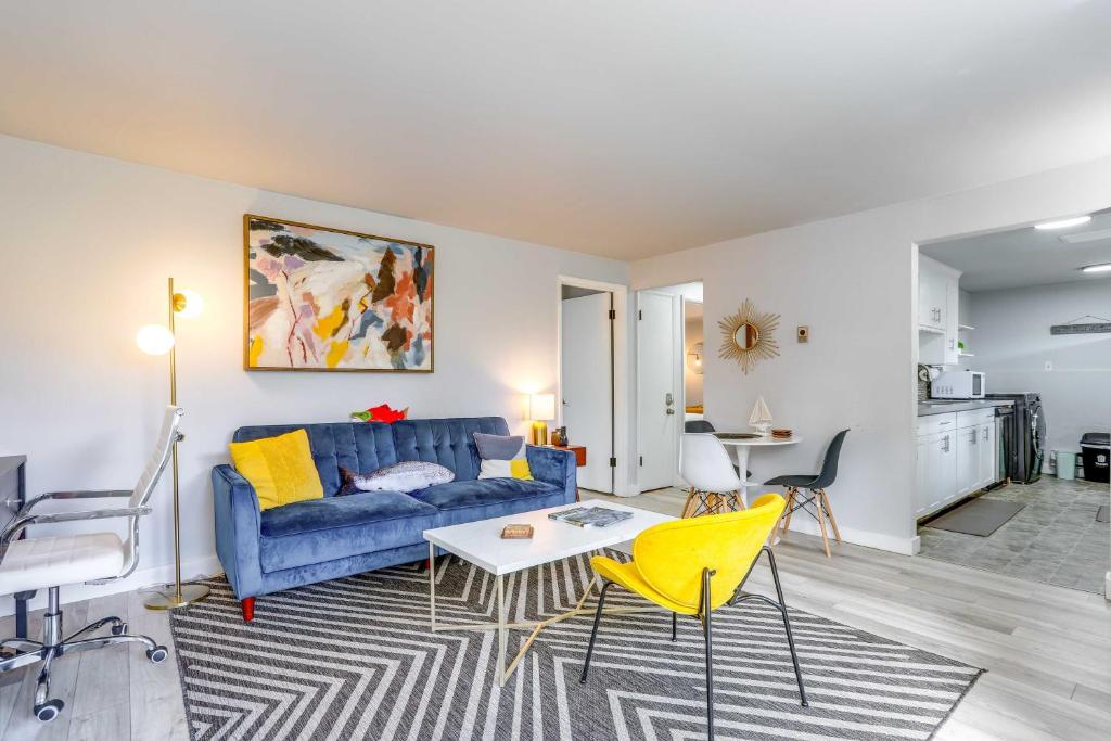 een woonkamer met een blauwe bank en gele stoelen bij Seattle Garden Apt Walk to Water and Amenities! in Seattle