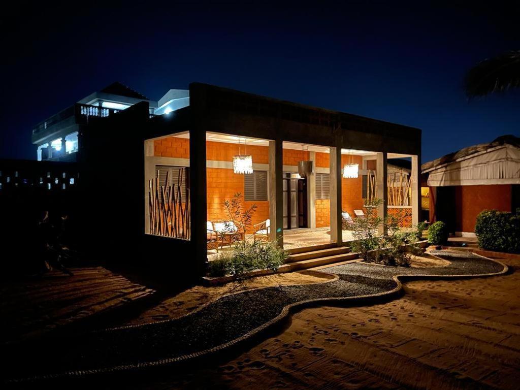 un pequeño edificio con luces encendidas por la noche en La Maison Bleue Lome, en Lomé