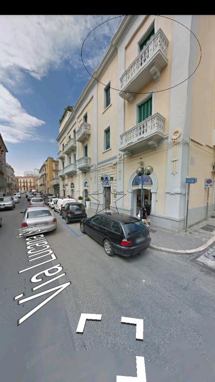 ulica z samochodami zaparkowanymi przed budynkiem w obiekcie B&B Lucana 22 w mieście Matera