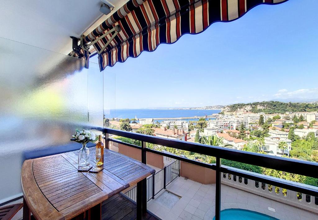 a balcony with a table and a view of the ocean at Nestor&amp;Jeeves - HUBLOT TERRASSE - Sea view - swimming pool in Nice
