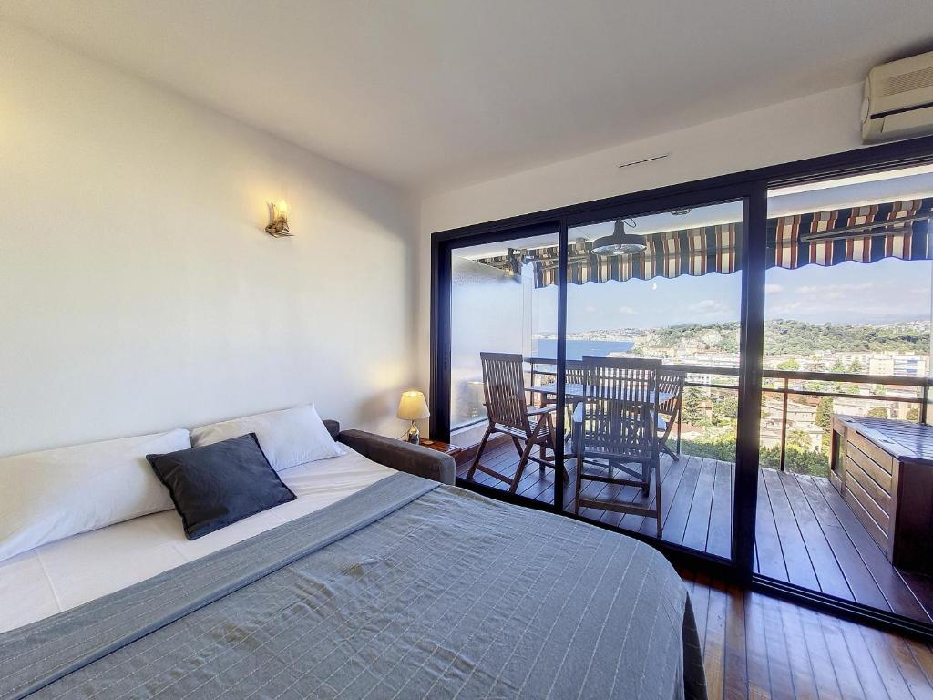 a bedroom with a bed and a balcony with a view at Nestor&amp;Jeeves - HUBLOT TERRASSE - Sea view - swimming pool in Nice