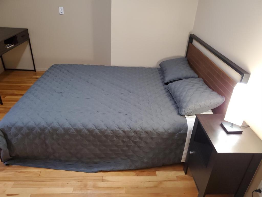 uma cama num quarto com uma mesa de cabeceira e uma cama sidx sidx sidx em Le1226 Apartment em Edmundston