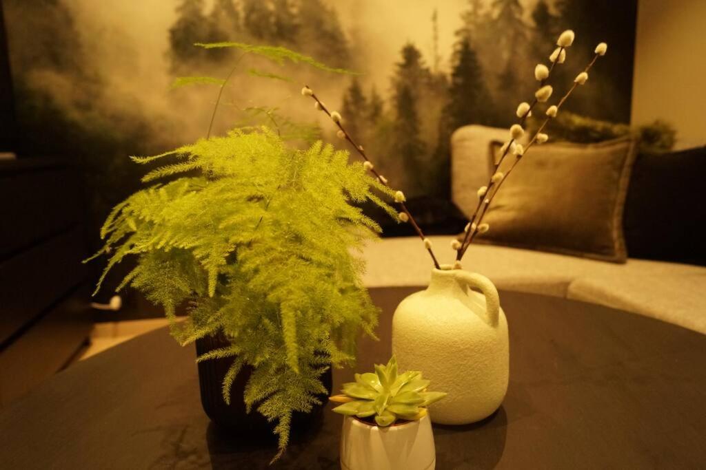 a living room with a vase and a plant on a table at Koselig leilighet i Langevåg in Holen