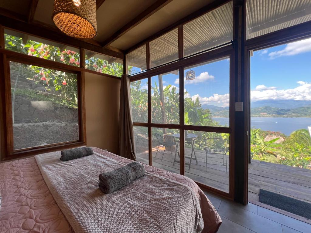 Dormitorio con cama y vistas al agua en Tierra Alta, Refugio de Montaña, Sauce en Sauce