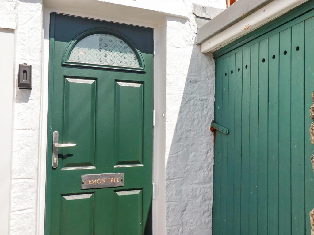 een groene deur op een wit gebouw met een groene garage bij Lemon Tree in Falmouth