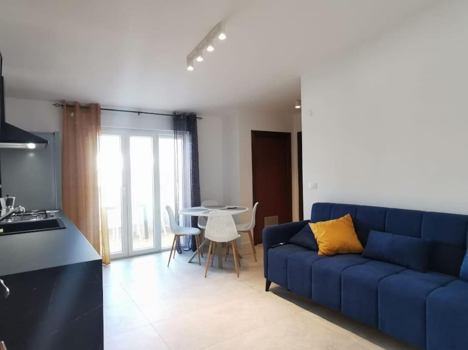 a living room with a blue couch and a table at Paradiso Marino in Scalea