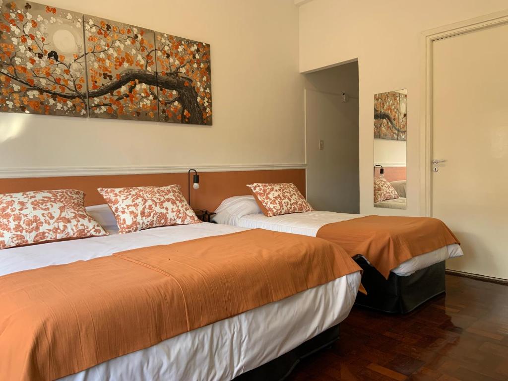 two beds in a room with a painting on the wall at Costa Rica Soho Rooms in Buenos Aires
