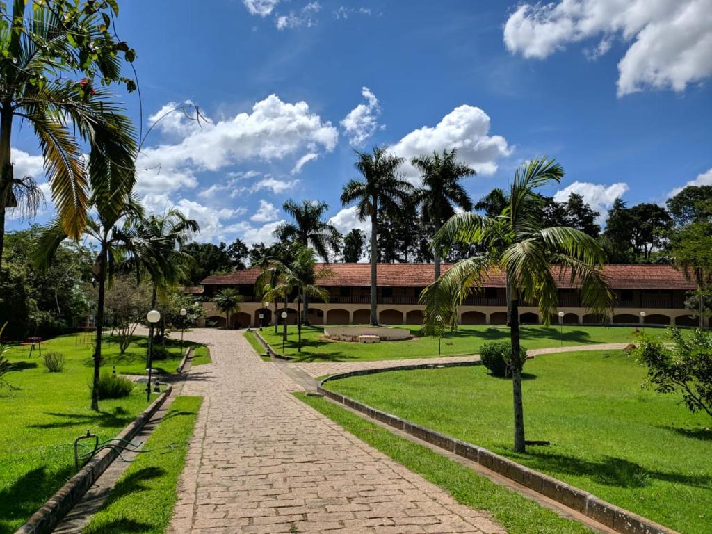 a pathway in front of a building with palm trees at Polo Hotel Fazenda in Indaiatuba