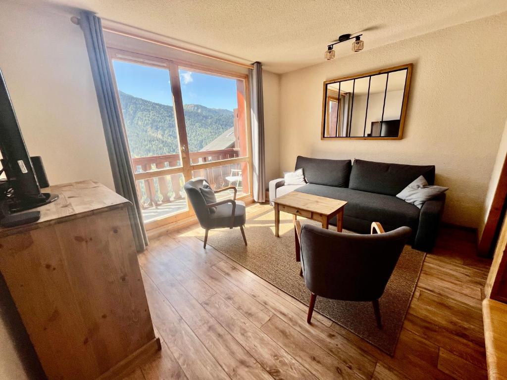 un salon avec un canapé et une table dans l'établissement VAUJANYLOCATIONS - LA FARE 30, à Vaujany