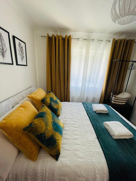 1 dormitorio con 1 cama grande con almohadas amarillas y azules en Simple Stay-Double Room Escape with Modern Luxury en Portchester