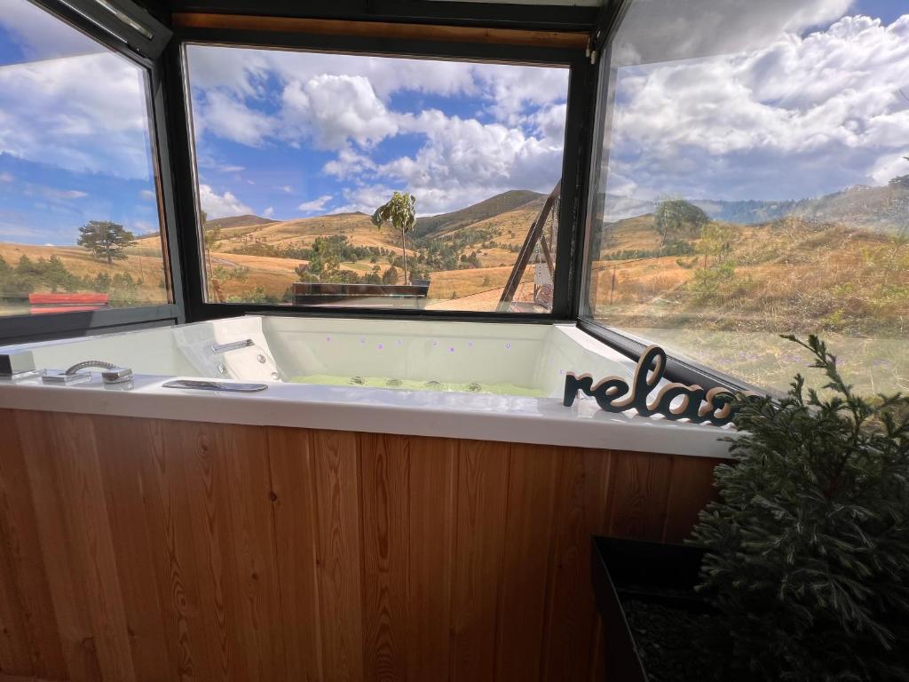 a bath tub in a room with a large window at Wild nest Deer Lux in Zlatibor
