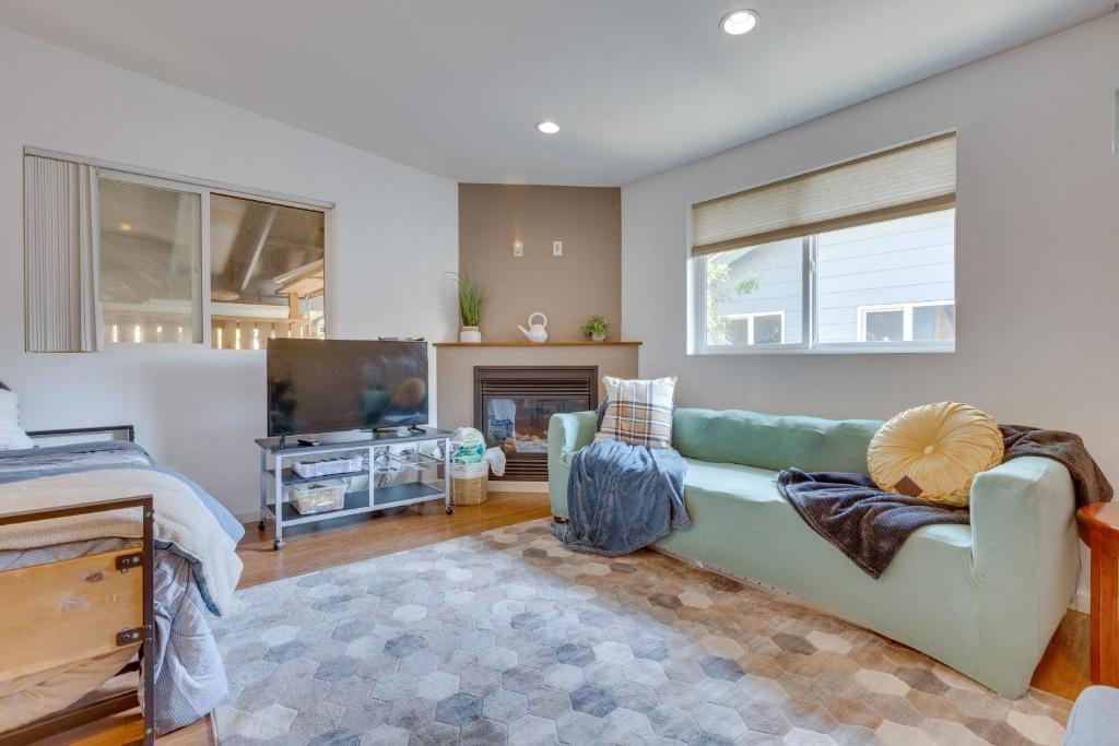 een woonkamer met een groene bank en een tv bij Cozy Seattle Retreat with Outdoor Dining Table! in Seattle