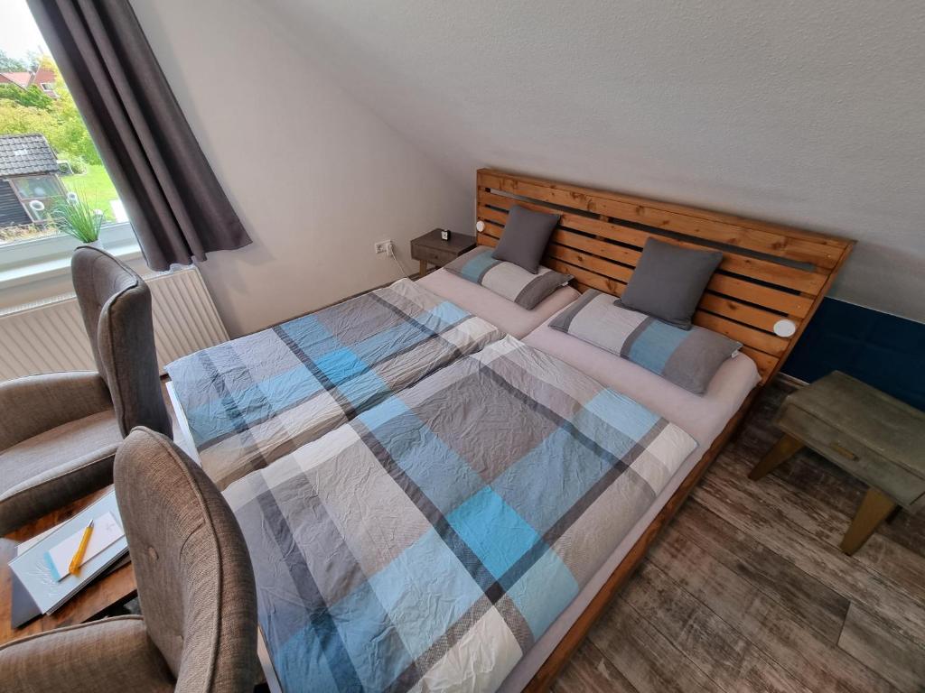 ein Schlafzimmer mit einem Bett und einem Tisch und einem Fenster in der Unterkunft FEWO FloTi Ferienwohnung Augustfehn in Apen