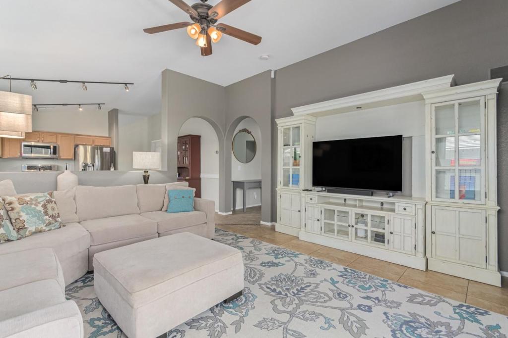 a living room with a white couch and a flat screen tv at Serenity Haven with Private Pool in Gilbert in Queen Creek