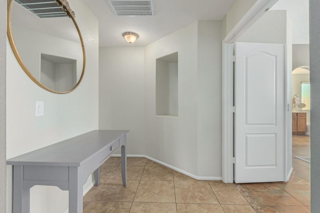 a white room with a table and a mirror at Serenity Haven with Private Pool in Gilbert in Queen Creek