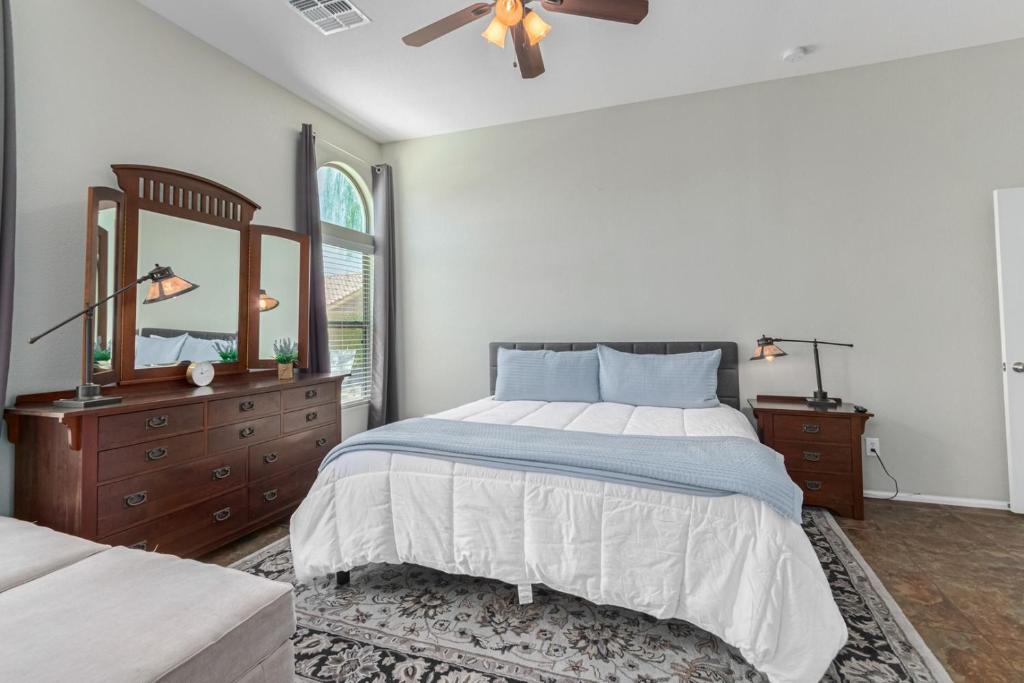 a bedroom with a bed and a dresser and a mirror at Serenity Haven with Private Pool in Gilbert in Queen Creek