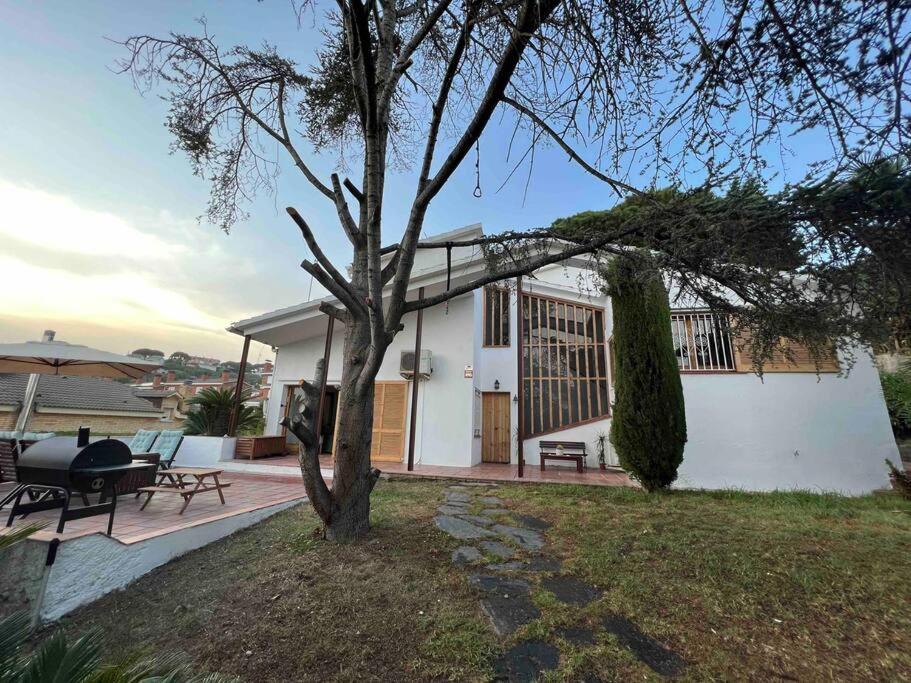 Una casa blanca con un árbol delante. en Casa familiar en la playa con piscina en Teià