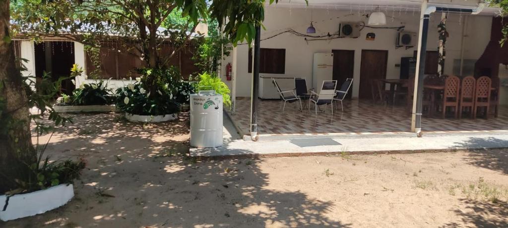 a house with a trash can in the yard at Hospedaje Emma in Ayolas