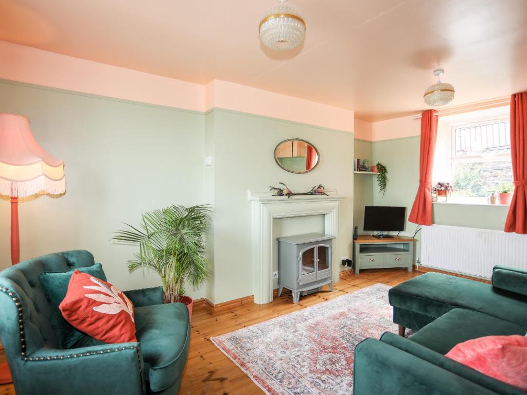 sala de estar con 2 sillas y chimenea en 12 Brynffynnon en Y Felinheli