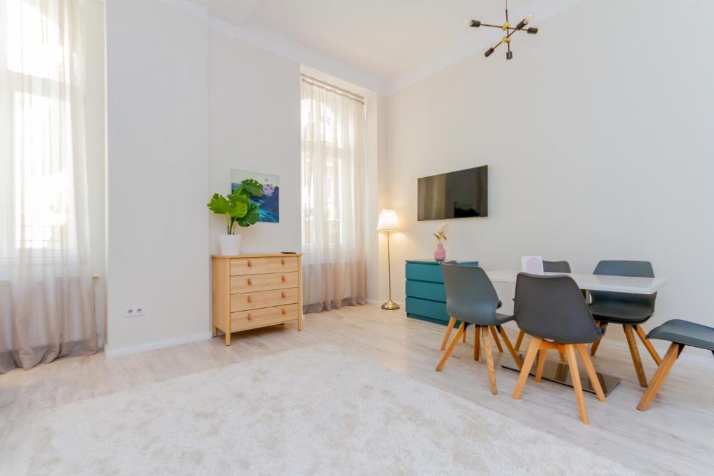 a living room with a table and chairs and a tv at Dohány Str. Downtown in Budapest