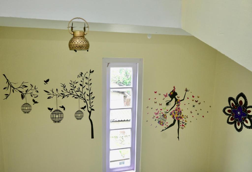 a room with a wall with a girl and a tree on it at Namaskar Lodge and Homestay in Guwahati
