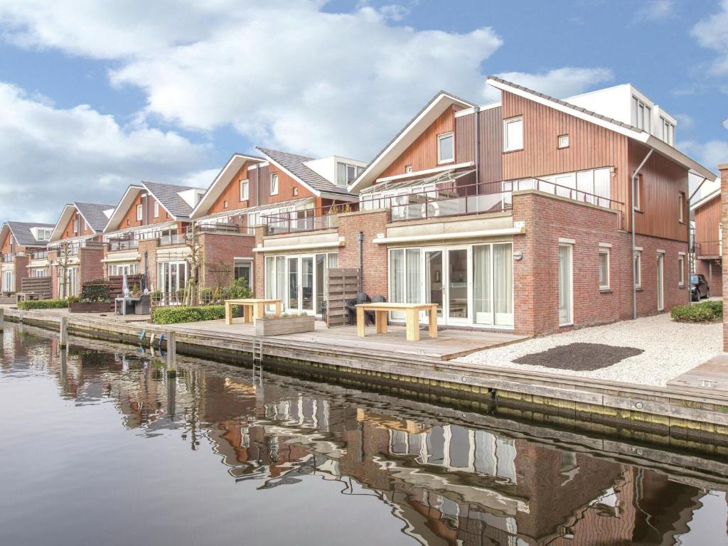 Une rangée de maisons près d'une rivière dans l'établissement Lake View apartment with dishwasher close to Amsterdam, à Uitgeest
