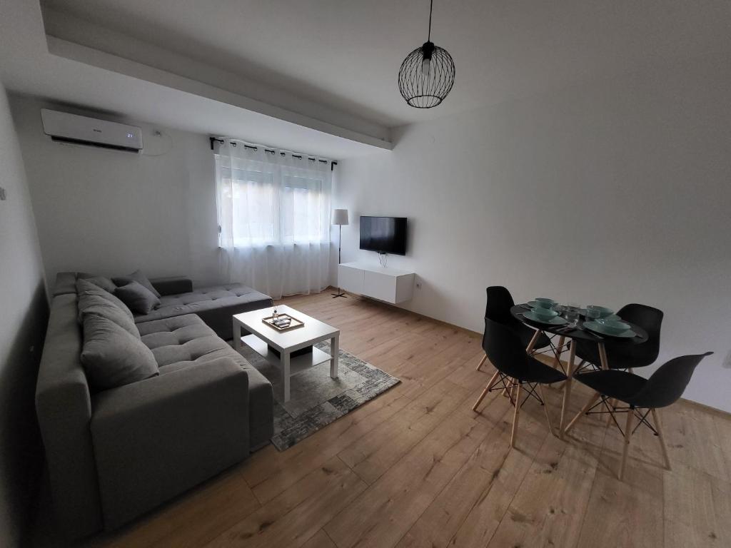 uma sala de estar com um sofá e uma mesa em Felix apartman Zajecar em Zaječar