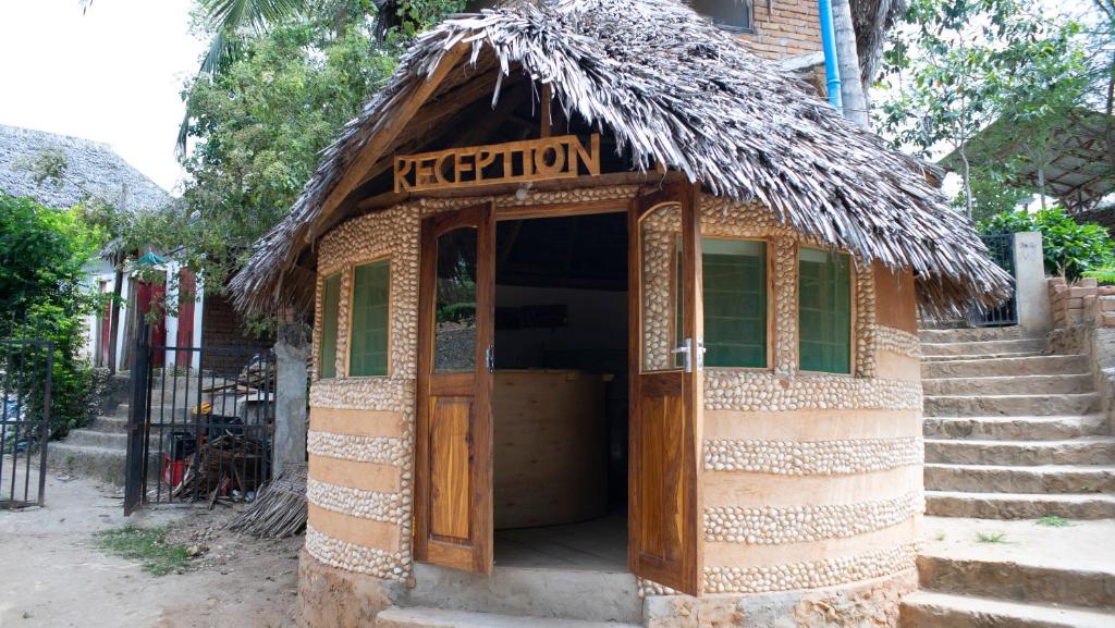 ein kleines Gebäude mit Strohdach in der Unterkunft AFLII Guest house in Mtwara