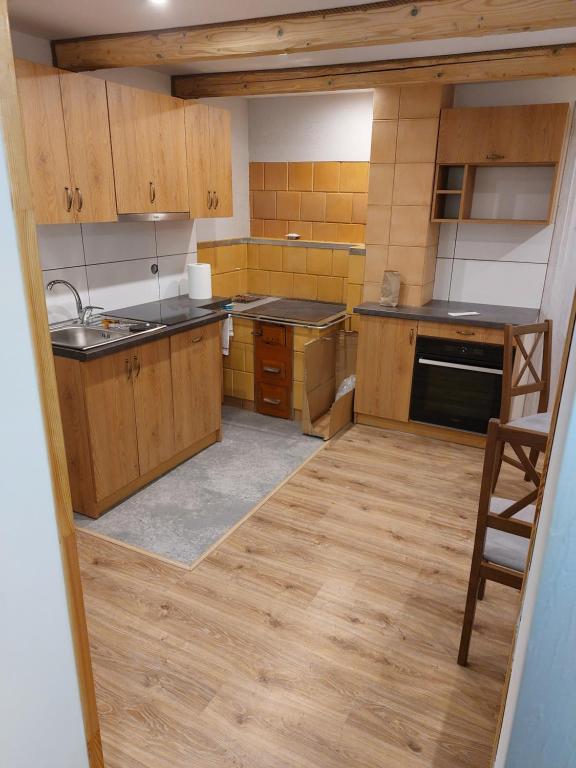 a kitchen with wooden cabinets and a counter top at Agroturystyka ,Jarzębina' in Harkabuz