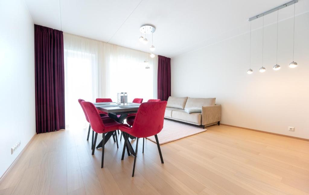 a dining room with a table and red chairs at New apartment in Haabersti in Tallinn