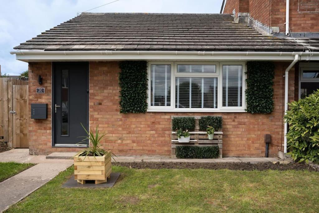 a brick house with a window and plants on it at Modern 2 bedroom Bungalow near Bath in Keynsham