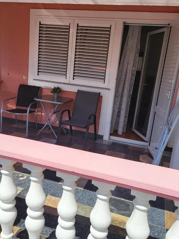 un banco rosa en el porche delantero de una casa en Soba L&L Povljana, en Povljana