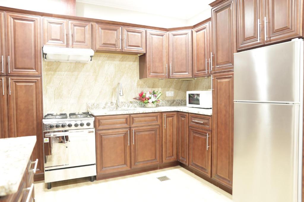 a kitchen with wooden cabinets and a stainless steel refrigerator at Myah's Hotel in Brighton Village