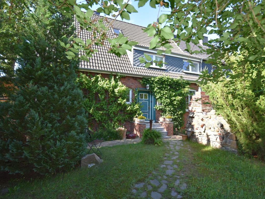 ボルテンハーゲンにあるPeaceful Apartment in Ostseebad Boltenhagen with Terraceの青い扉と庭のある家