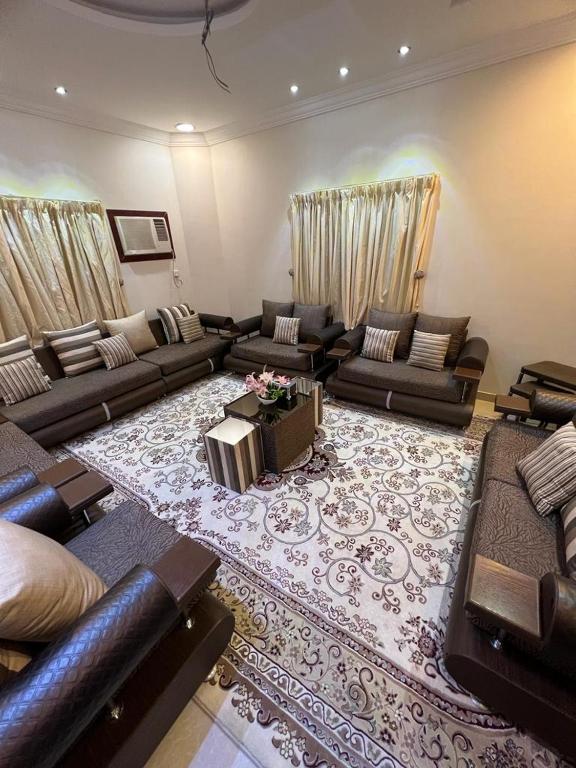 una gran sala de estar con sofás y una alfombra en Private Family's Apartment en Obhor