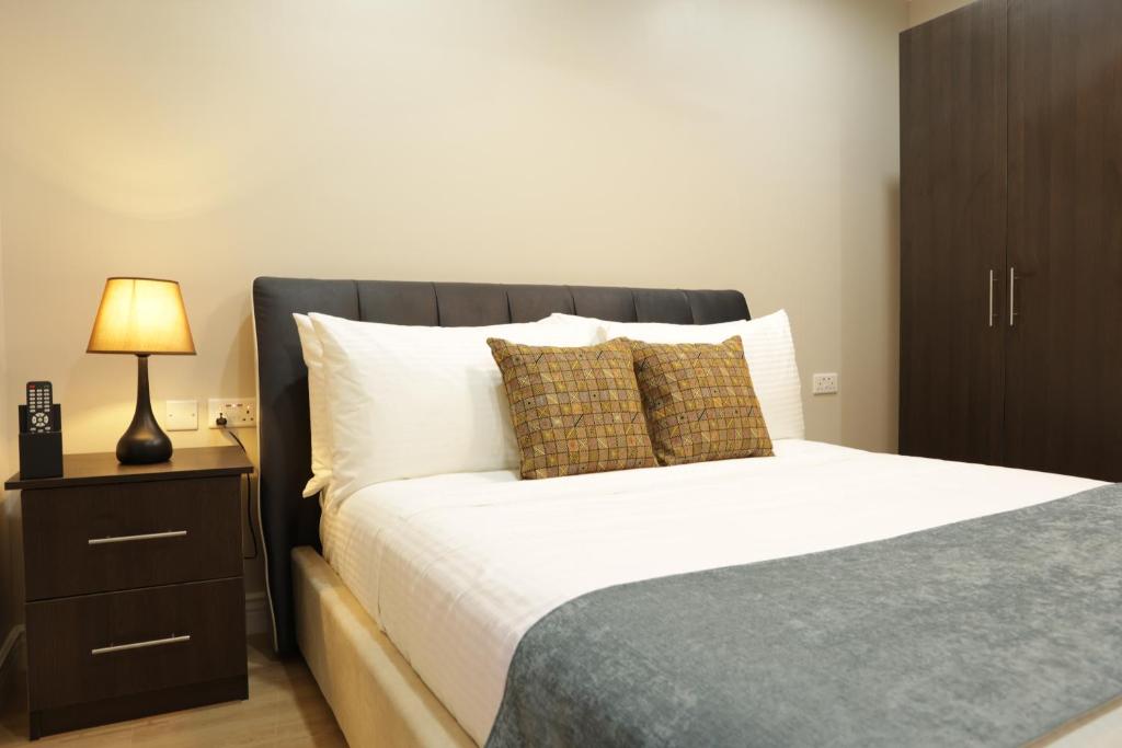 a bedroom with a large bed with a nightstand and a bed sidx sidx sidx at Myah's Hotel in Brighton Village