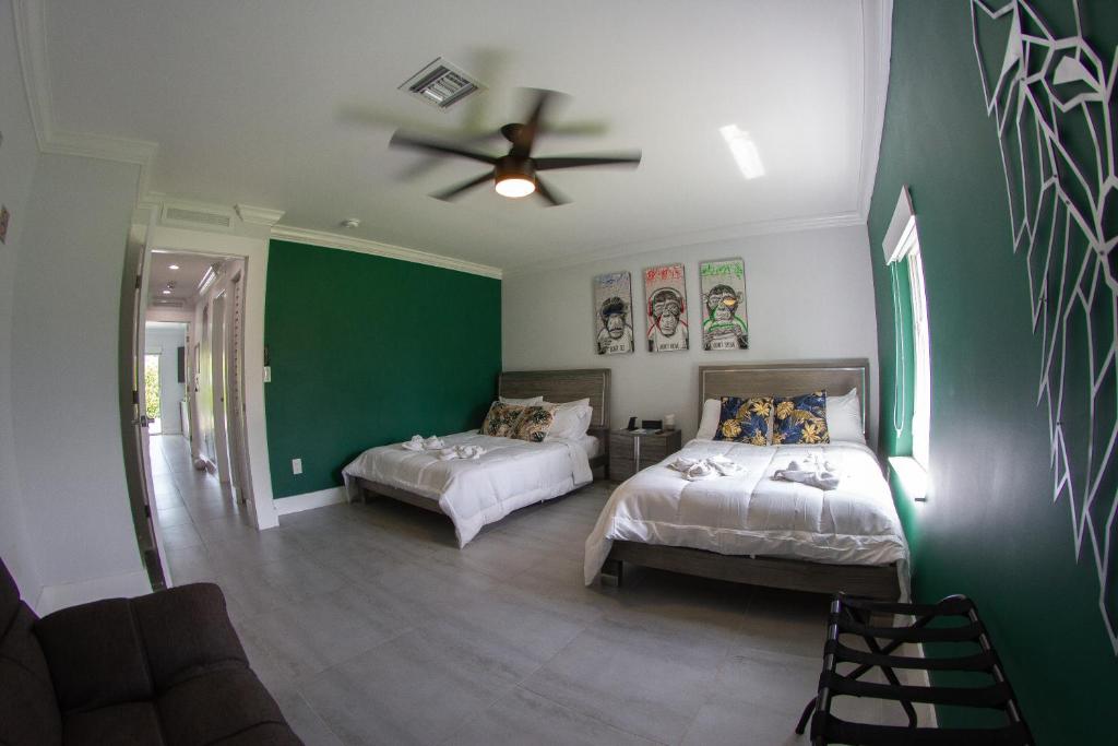 a bedroom with two beds and a ceiling fan at House Of Art - Luxury Villa with Pool & Jacuzzi! in Tamiami